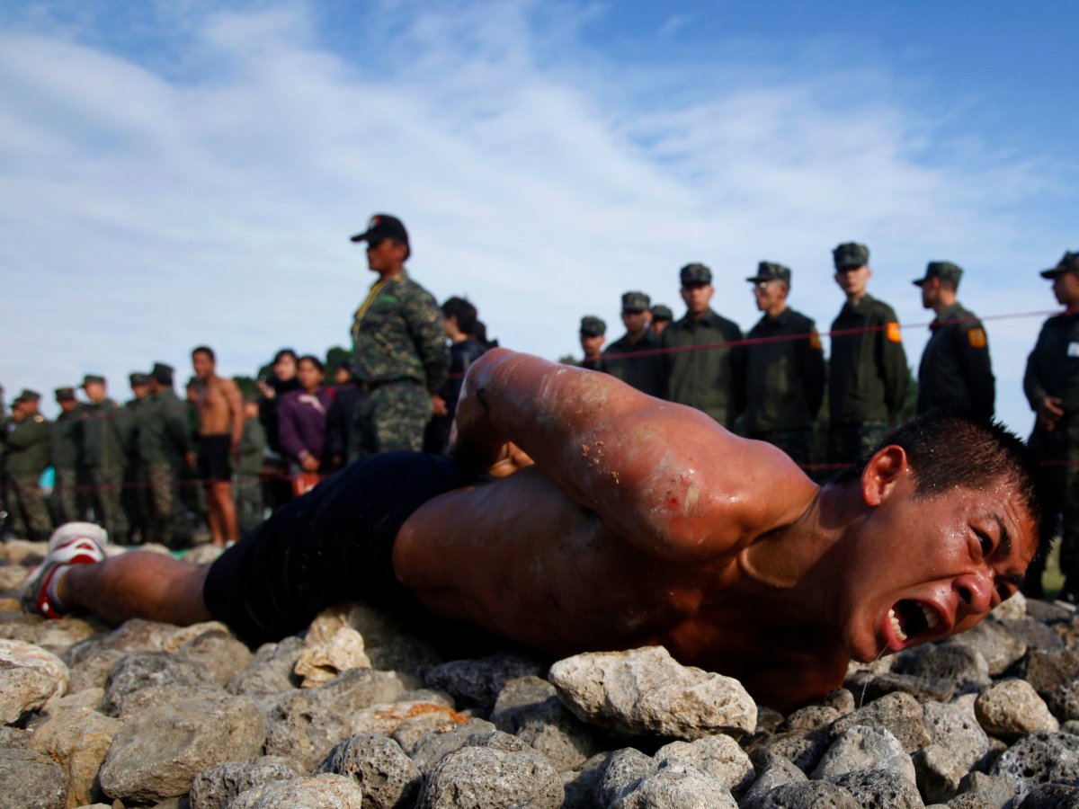A trainee leopard-crawls along a 50-meter-long path of jagged coral and rocks as part of the Taiwan marines' frogmen "Road to Heaven" test in Zuoying, Kaohsiung, on January 19, 2011. (Nicky Loh/REUTERS)